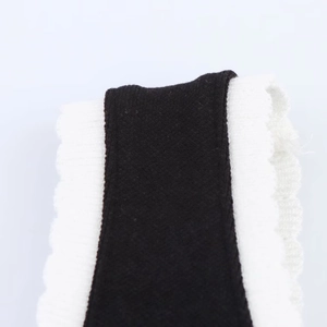 Gros plan sur les bords festonnés blancs contrastants d'un tissu en maille noire
