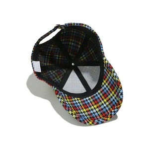 Detail view of colorful houndstooth baseball cap interior with stitching and wash label