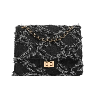 Classic black denim chain bag with quilted frayed edges and gold metal turn-lock