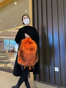 Detailansicht des flauschigen Kunstpelz-Rucksacks in leuchtendem Orange mit Nylonbändern