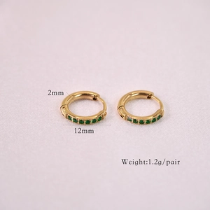 Macro shot of gold 14K stainless steel hoop earrings with micro-pave green zircon stones