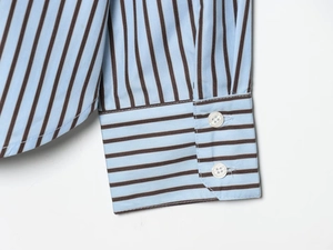 Detail of striped poplin shirt cuff with white buttons and curved hemline fabric