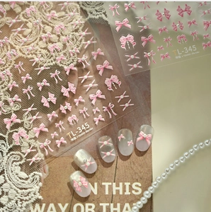 Detail of pink 3D bow nail art stickers with pearls and rhinestones on artificial nails