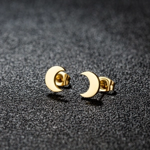 Boucles d'oreilles lune dorées minimalistes avec fermoir papillon sur fond sombre