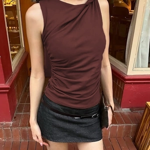 Detailed close-up of the asymmetrical draped neck and side ruching on the burgundy top