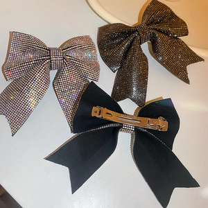 Close-up of sparkling full-drill bow hair clips and black fabric spring clips in detail