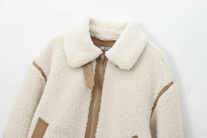 Détails de la veste polaire crème avec finitions marron et fermeture éclair en métal
