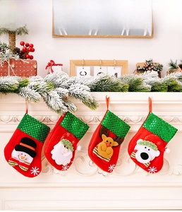 Detail of four sequined Christmas stockings with Santa and snowman on a white fireplace