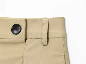 Dettaglio del tessuto twill kaki con bottone in resina nera e cuciture di qualità