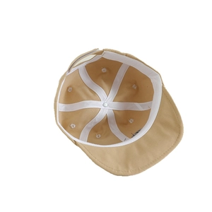Vue intérieure de la casquette bébé beige montrant les panneaux cousus et coutures renforcées