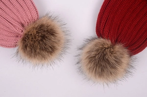 Detailed ribbed knit hats in pink and burgundy featuring soft faux fur pom-poms