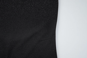Vue détaillée du tissu noir avec paillettes argentées sur la combinaison dos nu