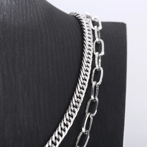 Detail of silver double layered stainless steel curb and oval link chain necklace