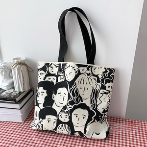 Artistic canvas tote bag with hand-drawn character illustrations on a checkered tablecloth