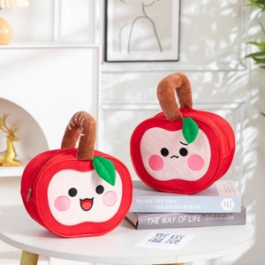 Detail view of red apple plush gift bag with soft green leaf and embroidered cute faces