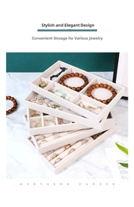 Close-up of stackable jewelry organizer trays with ring slots and velvet dividers