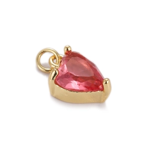 Close-up of gold plated heart-shaped pendant with pink zircon and jump ring attachment