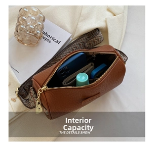 Detailansicht der braunen Leder-Zylindertasche mit bunt gewebtem breitem Schultergurt