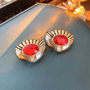 Vue macro de boucles d'oreilles vintage en forme de coquille avec gemme rouge et strass