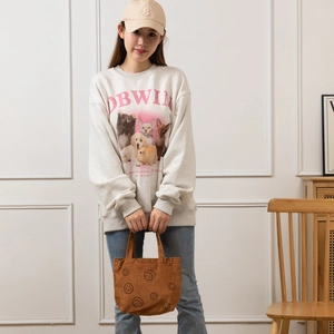 Détail d'un sac cabas en velours côtelé marron avec smiley et sweat-shirt gris imprimé chat
