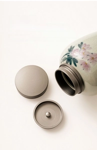 Detail view of pink cherry blossom ceramic tea canister with double alloy lids