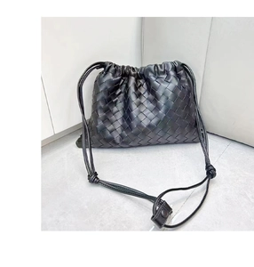 Close-up of black woven leather texture and drawstring closure on the elegant shoulder bag