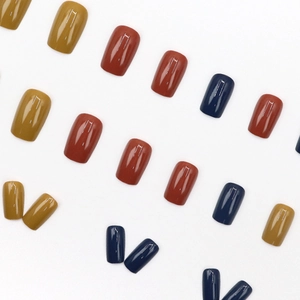 Glossy press-on nails in mustard yellow, brick red, and navy blue morandi tones