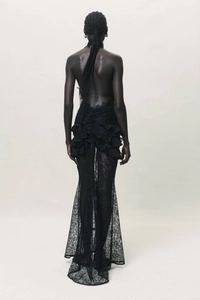 Detail of elegant backless evening dress with black lace texture and ruffle hem