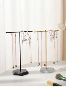 Close-up of T-bar jewelry stands with marble hexagonal bases for necklaces and earrings