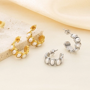 Detail of 18k gold and silver C-shaped stainless steel earrings with inlaid pearls