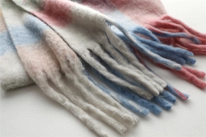 Close-up of pastel rainbow checkered scarf showing soft boucle yarn and woven fringes