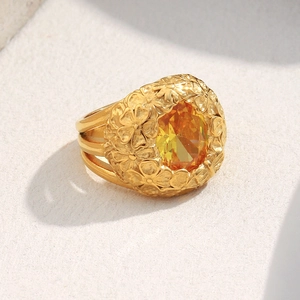 Detailed macro view of 18K gold plated floral ring with yellow oval cubic zirconia stone