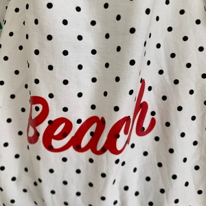 Detail der weißen Polka-Dot-Tragetasche mit stylischem rotem Beach-Schriftzug-Aufdruck