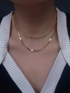 Close-up of double layer 18k gold plated snake and bead chains on model's neck