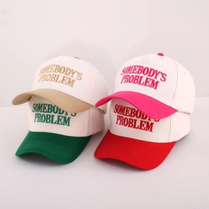 Detail of embroidered Somebody's Problem text on multi-color cotton baseball caps