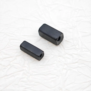 Close-up of matte black titanium steel rectangular beads with 18K gold plated through-holes
