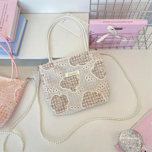 Détails de broderie en dentelle florale et élégante chaîne de perles sur le sac à main