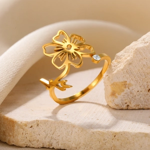 Detail of gold floral ring featuring cutout petals and a sparkling cubic zirconia stone