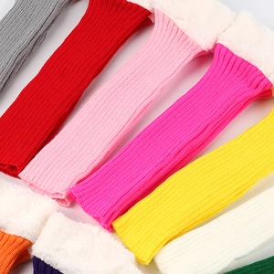 Close-up of assorted colorful knitted leg warmers with white faux fur trim on white background