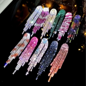 Elegant long tassel rhinestone earrings in silver pink and gold shown in luxury lighting