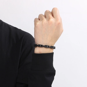Detail of an 8mm black stainless steel watchband link bracelet on male model wrist