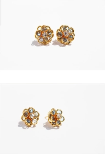 Macro detail of sky blue crystal flower earrings with gold petals and zircon accents
