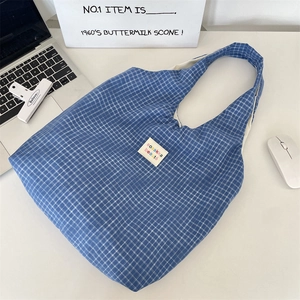 Vue de dessus du sac cabas en coton à carreaux bleus sur un bureau professionnel