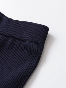 Close-up of dark navy ribbed knit fabric texture showing vertical stripe patterns