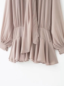 Détail de robe en mousseline rose poudré avec ourlet à volants et taille élastique