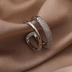 Macro shot of silver-colored double-layer ring with micro-pave zircons on silk fabric