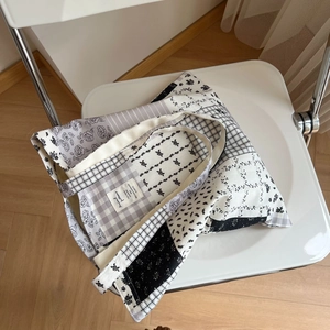Detail of grey floral patchwork tote bag showing cotton texture on a white chair