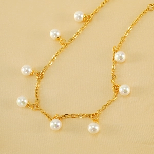 18K gold plated stainless steel anklet with white pearls on a beige fabric background