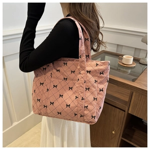 Corduroy tote bag featuring pink quilted rhombus patterns and black bow detail
