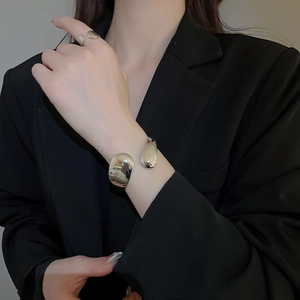 Polished silver irregular water drop bangle and ring set styled on a model in a black blazer